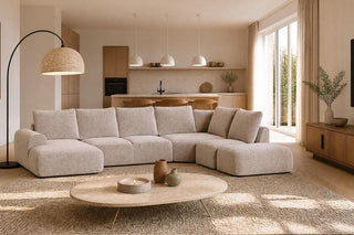 Modern living room with a beige sectional sofa, coffee table, and decorative items.
