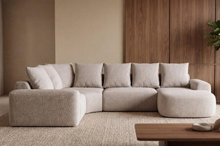 Beige sectional sofa in a modern living room with wooden coffee table and plant.