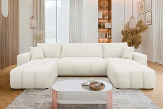 White sectional sofa in a modern living room with a coffee table and decorative items.