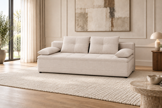 A modern tufted sofa in a light beige fabric, styled in a bright, contemporary living room with a textured rug, wooden floor, and wall art.