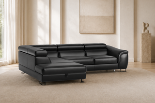 A modern black leather sectional sofa with a chaise lounge, positioned on a large beige area rug in a minimalist, warm-toned living room.