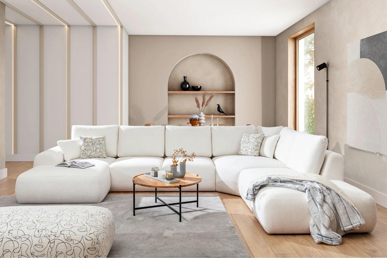 Modern living room with a white sectional sofa, coffee table, and decorative items.