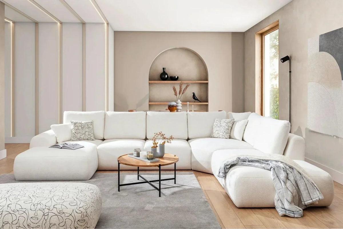 Modern living room with a white sectional sofa, coffee table, and decorative items.
